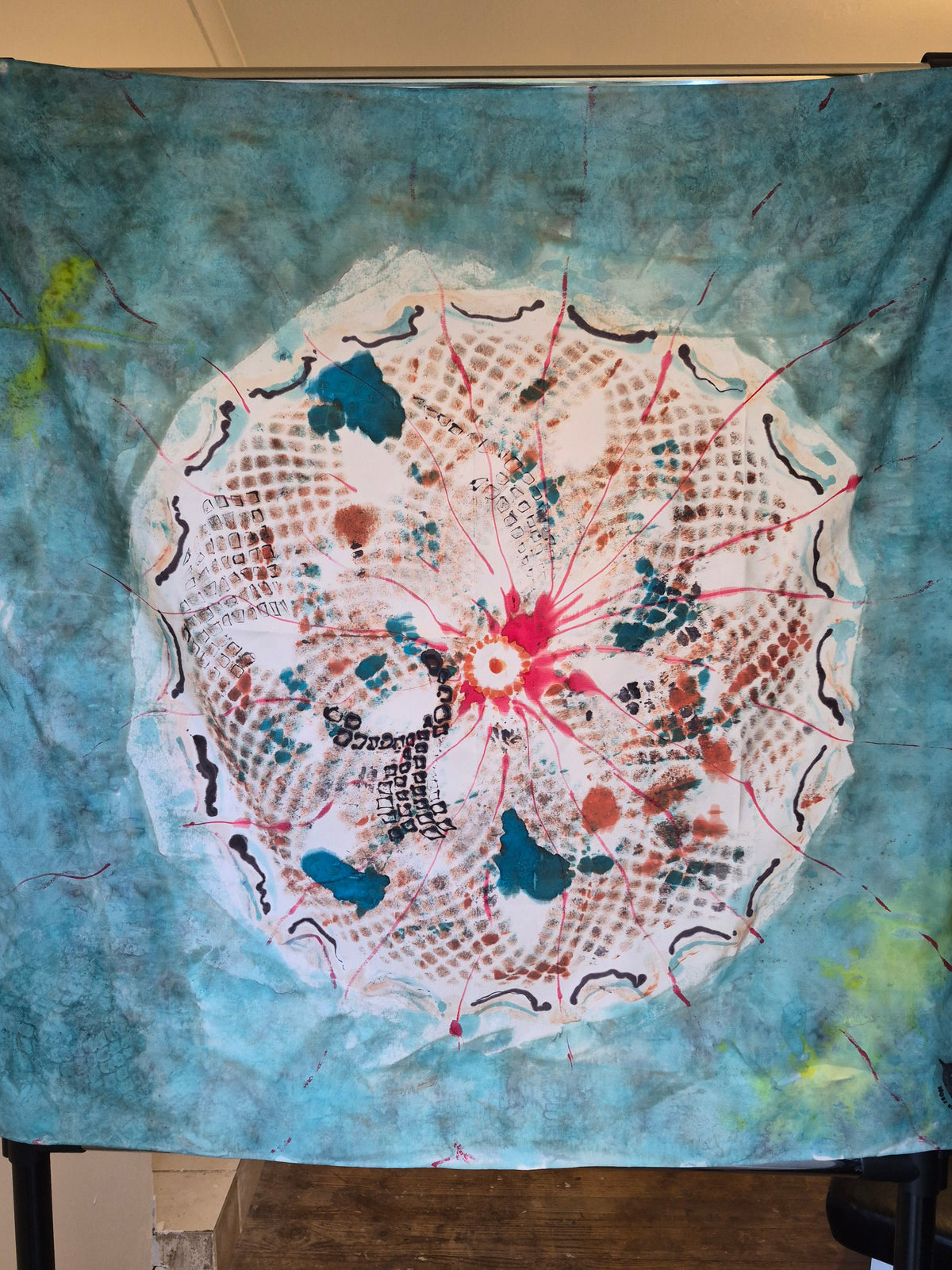 Hand-painted Mulberry silk scarf featuring a large circular abstract design in turquoise, white, coral, red, brown and black.