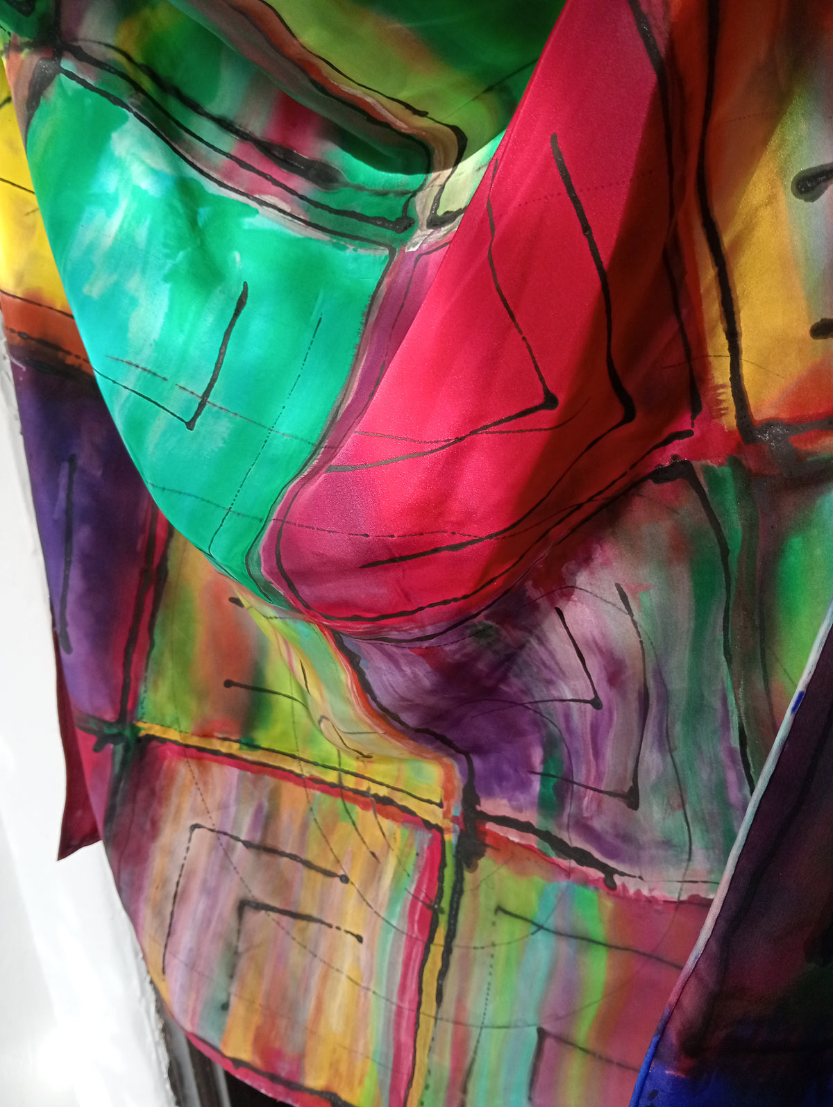 A close up with more detail of the hand-painted mulberry silk scarf with multicolours and black lines